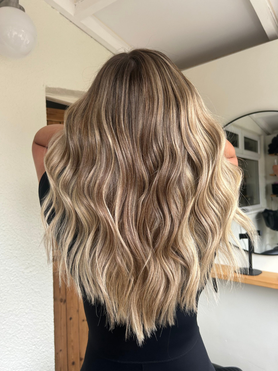 Long wavy blonde balayage hair styled at Caitlin Rafferty Hair
